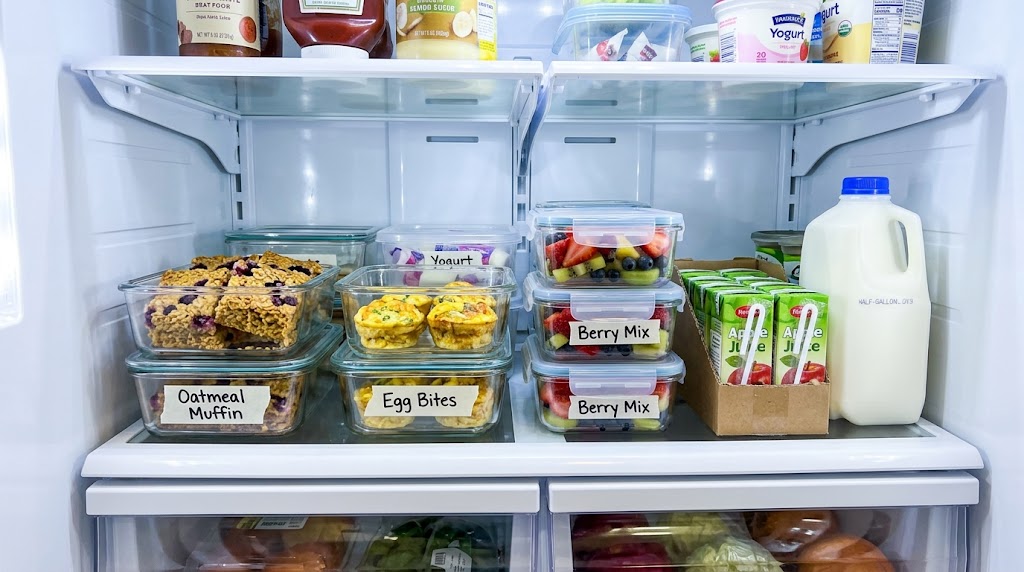 Labeled meal prep containers organized on a refrigerator shelf with toddler breakfasts